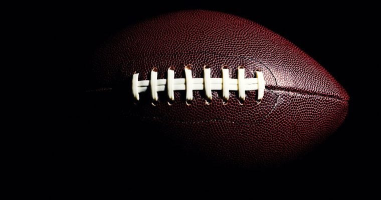 Close-Up Photo of Textured Brown American Football with White Stitching