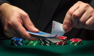 Cards Dealer Pulls Out Ace from Deck of Playing Cards with Stacks of Poker Chips on Table