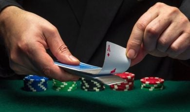 Cards Dealer Pulls Out Ace from Deck of Playing Cards with Stacks of Poker Chips on Table