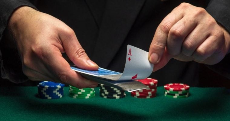 Cards Dealer Pulls Out Ace from Deck of Playing Cards with Stacks of Poker Chips on Table
