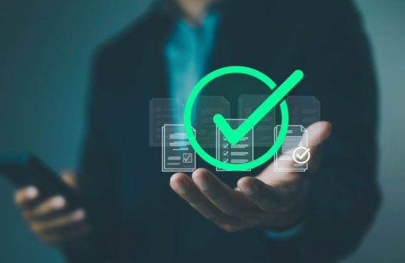 Man Holding Cell Phone in One Hand And the Other Palm Faces Up with Green Check Mark Hovering Above