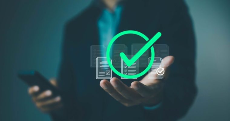 Man Holding Cell Phone in One Hand And the Other Palm Faces Up with Green Check Mark Hovering Above
