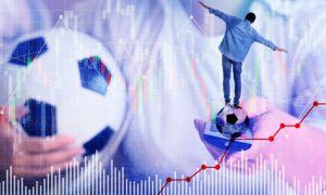 Man Holds Soccer Ball in One Hand and TV Remote In Another With Smaller Man Balancing and Graphs Below