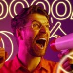 Neon Letters Spell GOAL with Whistle and Soccer Ball Behind Man Yelling in Megaphone