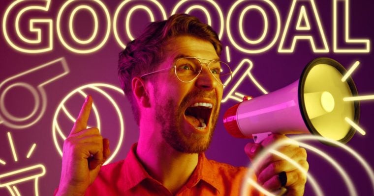 Neon Letters Spell GOAL with Whistle and Soccer Ball Behind Man Yelling in Megaphone