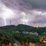 Huge Thunderstorm with Many Lightning Strikes Hit Green Hills Above Town Tucked Inside