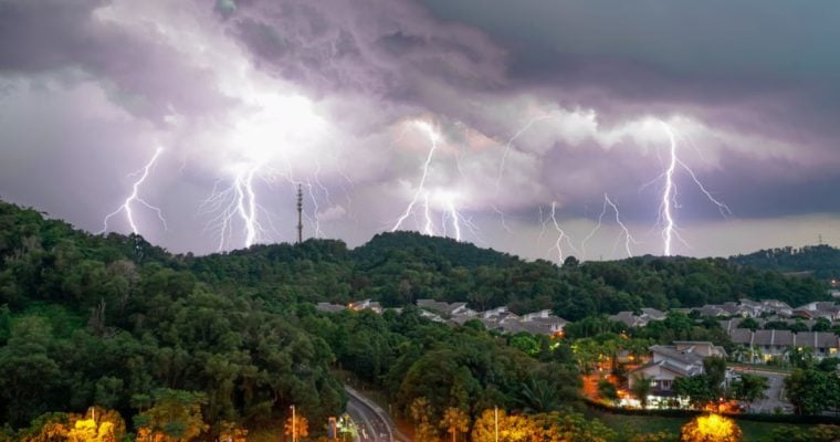 Huge Thunderstorm with Many Lightning Strikes Hit Green Hills Above Town Tucked Inside