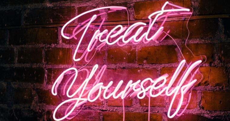 Hot Pink Neon Sign Hanging on Red Brick Wall Reads Treat Yourself