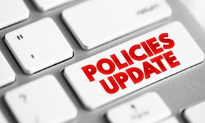 Computer Keyboard Button Reads Policies Update in Red Font