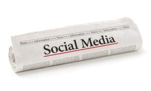 Newspaper Reads Social Media Headline Rolled Up on Isolated White Background
