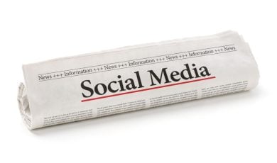 Newspaper Reads Social Media Headline Rolled Up on Isolated White Background
