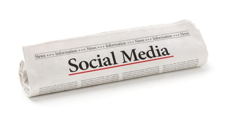 Newspaper Reads Social Media Headline Rolled Up on Isolated White Background