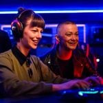 Neon Blue Lights Inside Game Room Behind Two Women Playing PC Game