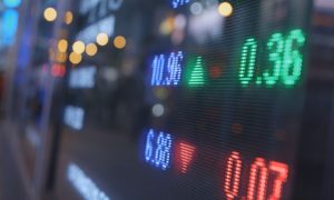 Blue, Green and Red Numbers Displayed on a Stock Board on Trading Floor