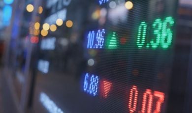 Blue, Green and Red Numbers Displayed on a Stock Board on Trading Floor