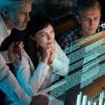 Three People Stare at Computer Monitor with Digital Image Overlay of Data and Charts