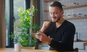 excited player winning a slots tournament on his mobile phone
