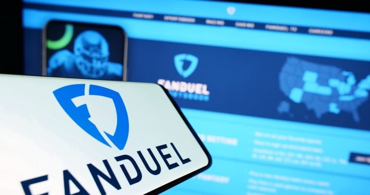 Picture of FanDuel logo on phone next to PC screen.