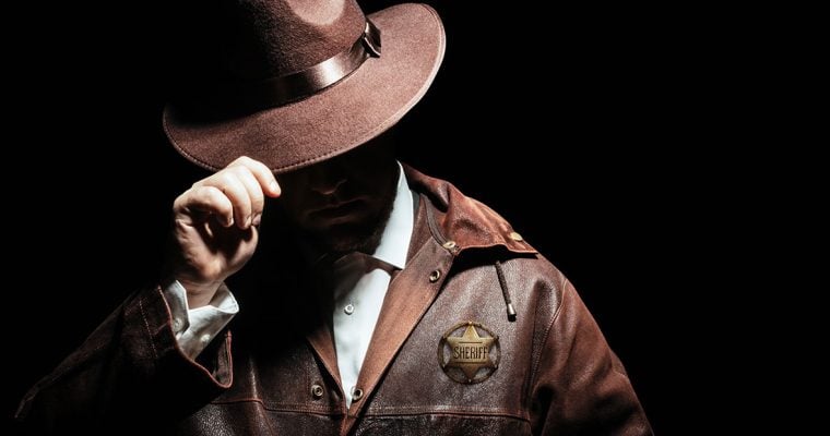 Tough-looking man with leather jacket and sheriff's badge