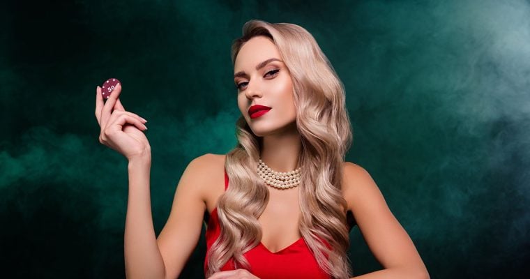 Attractive woman playing or dealing poker, wearing a red dress, holding a poker chip.