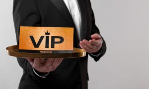 a man in a suit holding a tray that features a vip nameplate