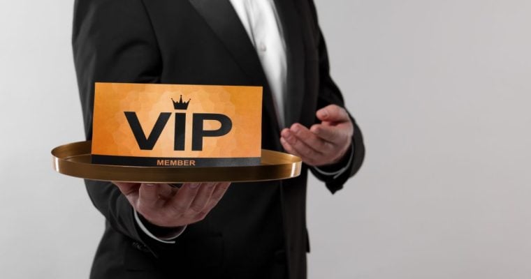 a man in a suit holding a tray that features a vip nameplate