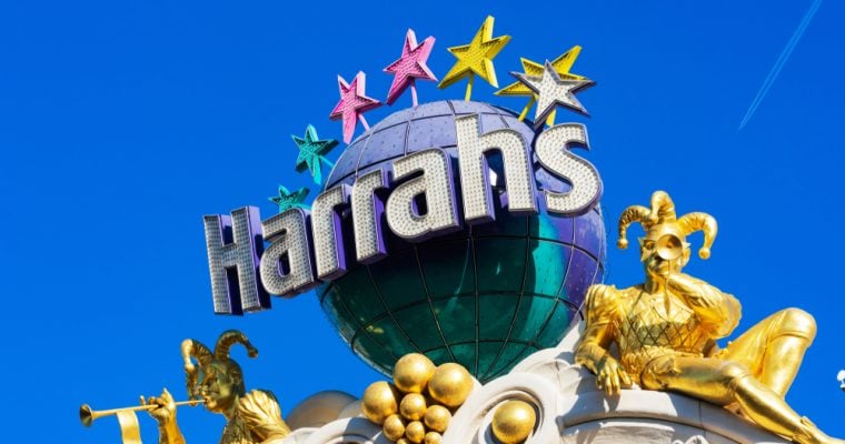 Two gilded jester, joker sculptures blow trumpets seating between globe and stars, and on outdoor marquee of Harrah's casino and hotel