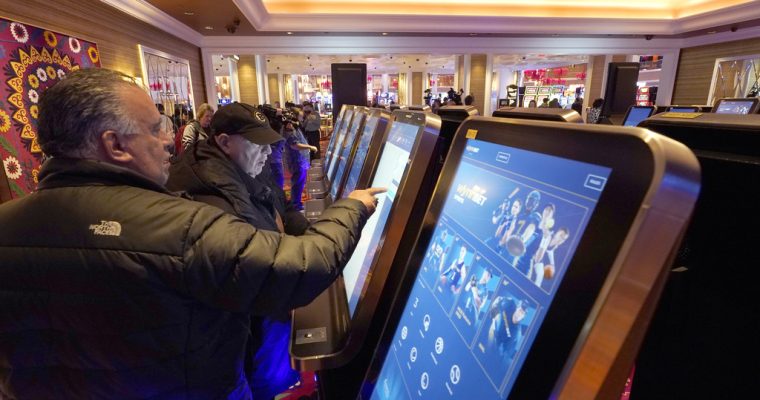 Sports bettors at Encore Boston Harbor, one of three Massachusetts casinos fined for accepting bets on in-state college basketball teams.
