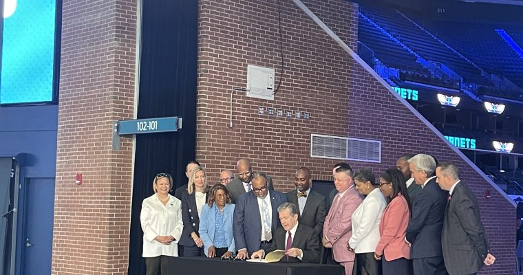 Gov. Roy Cooper signs the North Carolina sports betting bill at Spectrum Center in Charlotte.