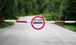 a stop sign and barrier on a road