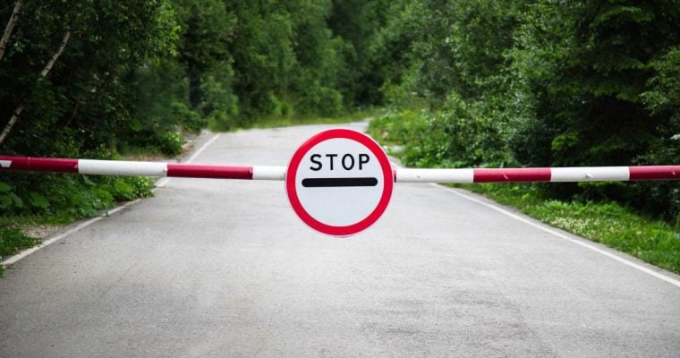 a stop sign and barrier on a road