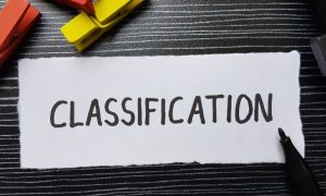 a piece of white paper on a black table that reads classification