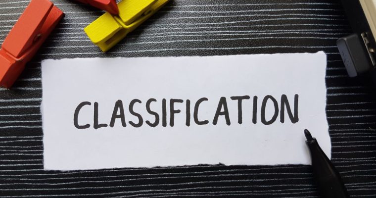 a piece of white paper on a black table that reads classification