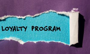a piece of purple paper with a tear that reads loyalty program under it