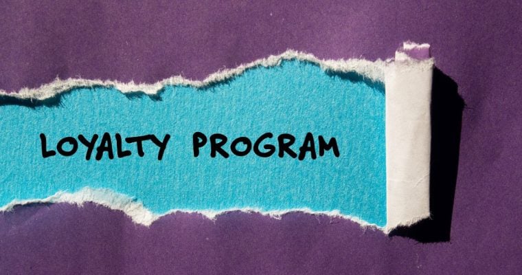 a piece of purple paper with a tear that reads loyalty program under it