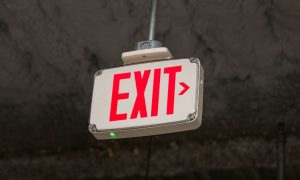 an exit sign hanging from a ceiling